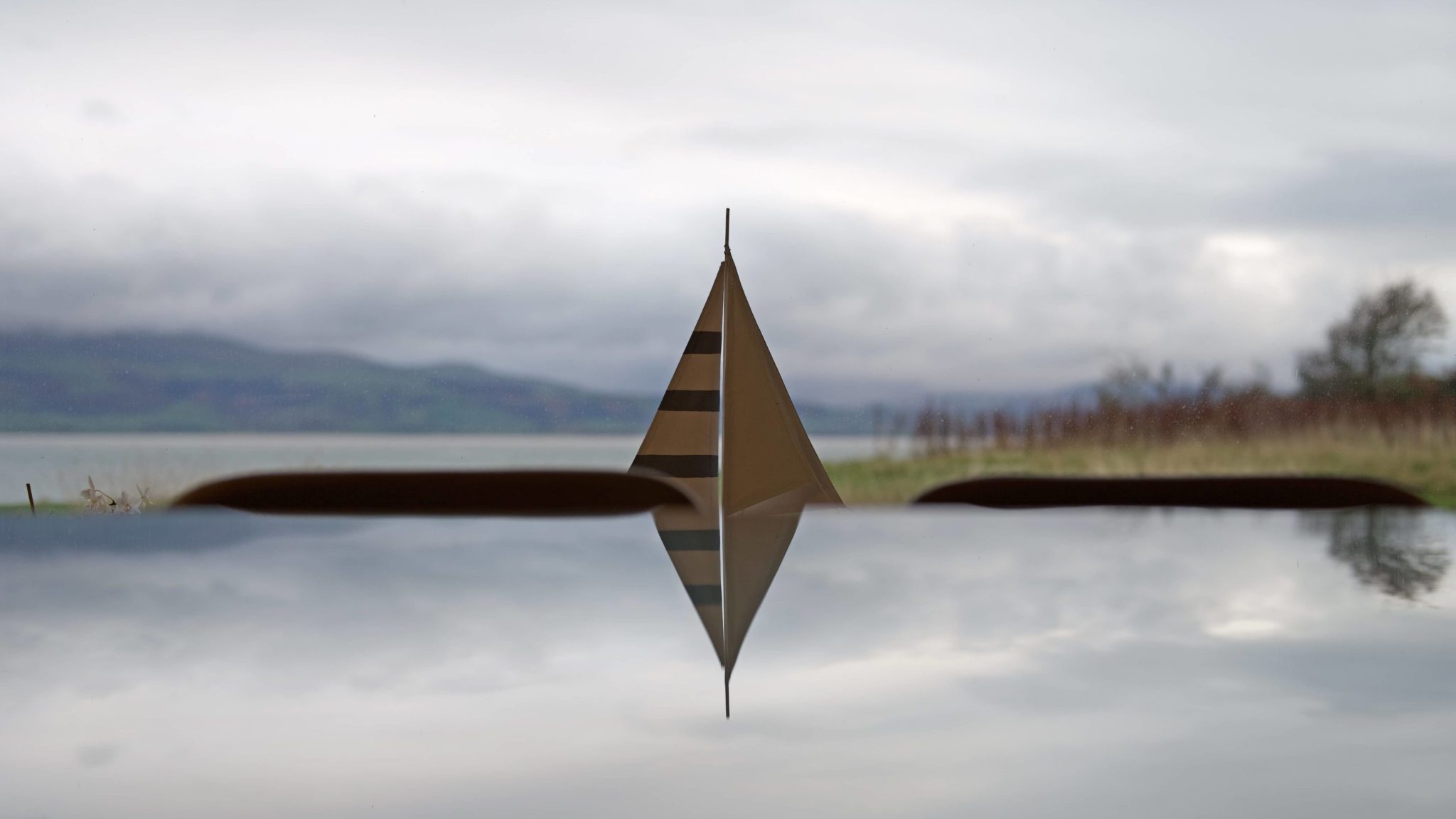 a paper boat floating on top of a lake.